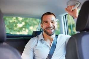 Cheerful businessman sitting in a car